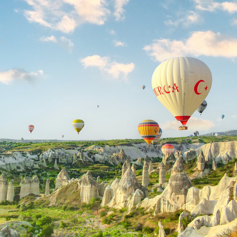 Balloons over eroded rock valleys at first light.