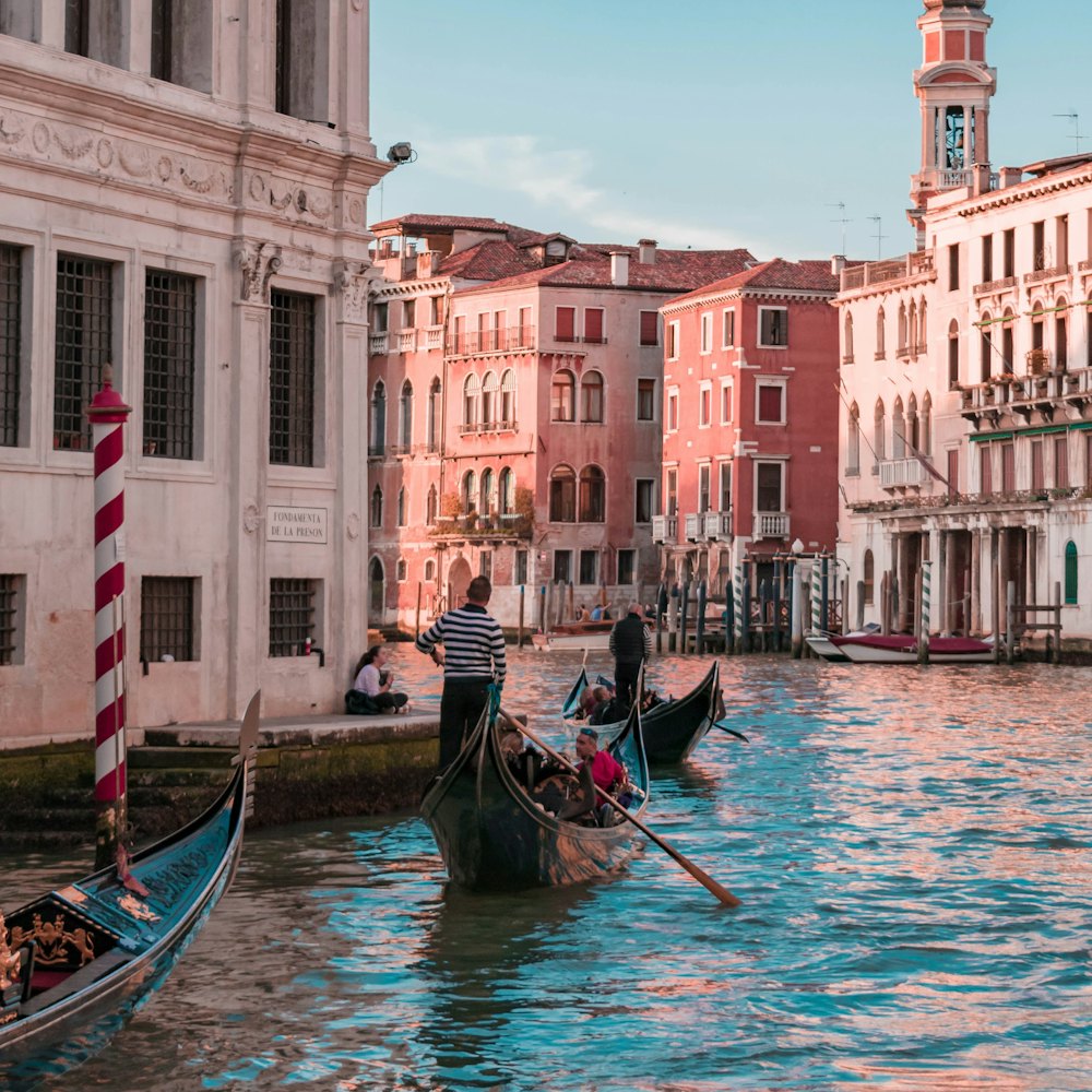 Gondolas on a canal between pastel palazzi.